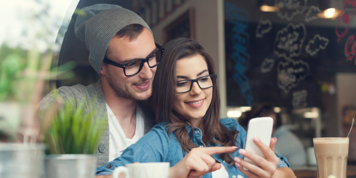 Couple using mobile phone smiling